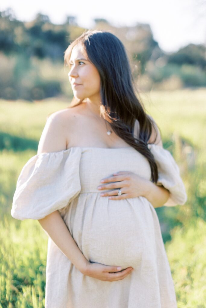 Ventura County maternity photos at the beach during golden hour, pregnant mother in flowing neutral dress at Oxnard Beach Park, coastal maternity photography inspiration in Southern California, what to wear for maternity photos in Ventura County, luxury maternity session near Ojai and Ventura beaches, romantic pregnancy photos with soft natural light, California maternity photographer capturing emotional motherhood moments outdoors, ventura county maternity, ventura county maternity photographer