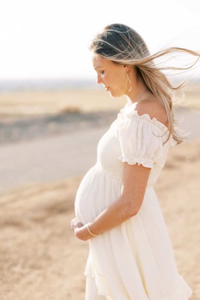 Ventura County maternity photos at the beach during golden hour, pregnant mother in flowing neutral dress at Oxnard Beach Park, coastal maternity photography inspiration in Southern California, what to wear for maternity photos in Ventura County, luxury maternity session near Ojai and Ventura beaches, romantic pregnancy photos with soft natural light, California maternity photographer capturing emotional motherhood moments outdoors, ventura county maternity, ventura county maternity photographer