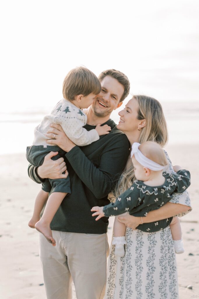 Family of four smiling together during fall family photos in Ventura County, family group shot in ventura county for fall family photos, candid shots of family fall photos, santa holiday mini sessions, holiday mini sessions ventura county, christmas tree family session in ventura county, fall beach photos of family together in ventura county, fall beach photos of family together in San Diego, fall beach photos of family together in Orange County, holiday mini session photos in Los Angeles